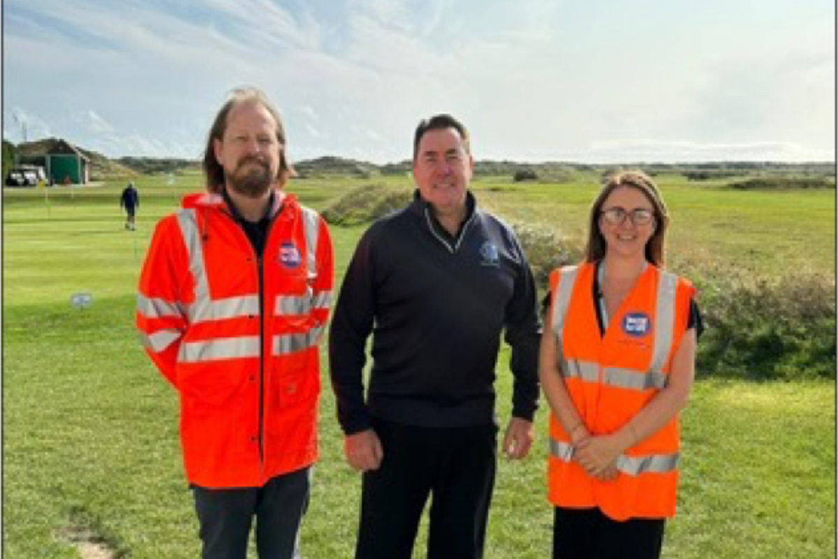 Golfer standing next to two Southern Water workers