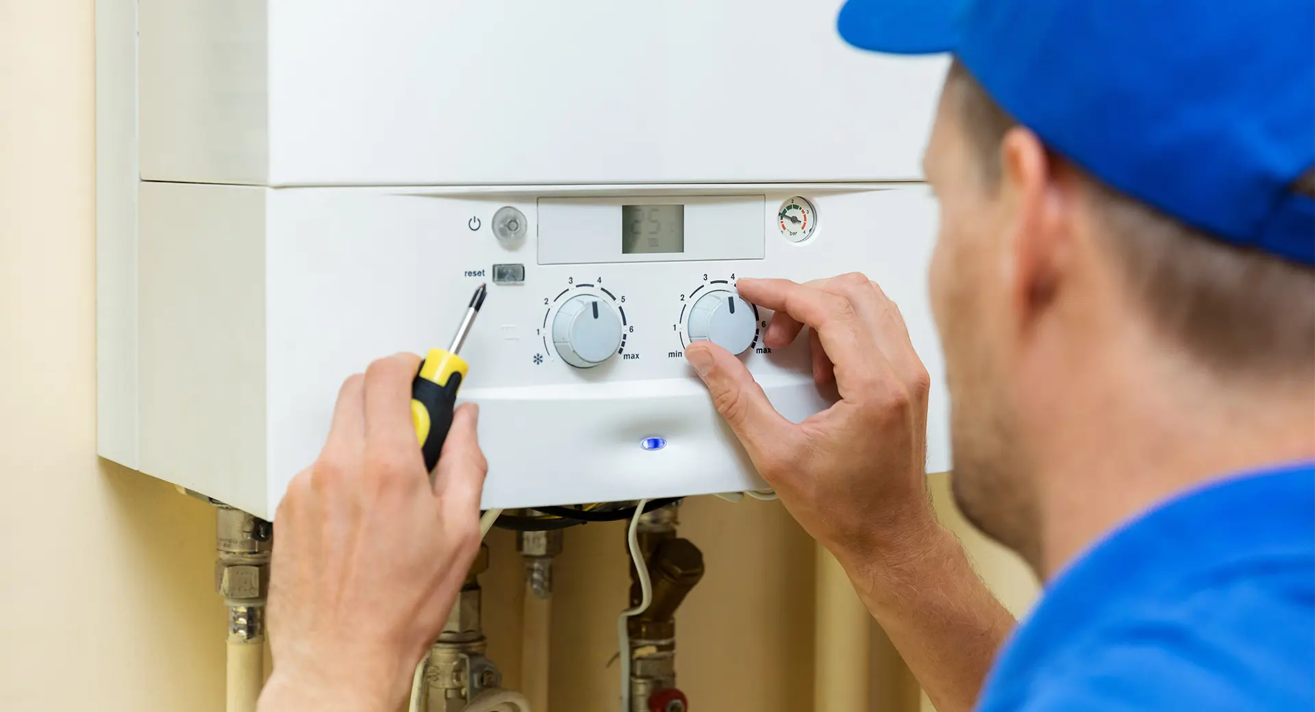 A worker adjusting a boiler